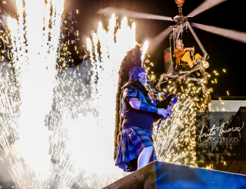 Lifestyle photography - The bagpiper sets the stage afire while the aviator watches from above during a performance with Circus Orange at Supercrawl 2013 in Hamilton, Ontario. Scenes captured of the performers and visitors at Supercrawl in Hamilton, Ontario.
© Anita Thomas - Urbanmoon Photography. All Rights Reserved. pyrotechnics and the bagpipe
